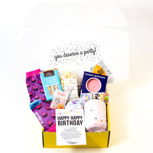 Birthday Care Package for Her filled with birthday socks, pretzels, cake bath bomb, popcorn, treat magnets, and pink confetti mug